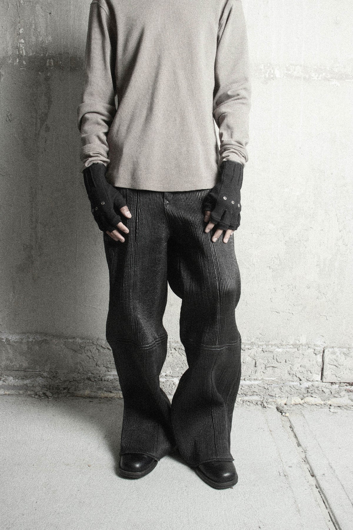 Full-length look: model in a taupe waffle top and ribbed black trousers wearing Ākhira Rib Gloves